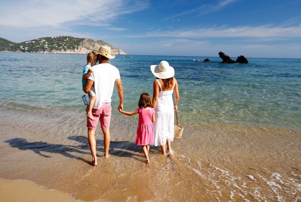 Family strolling along the beach shore